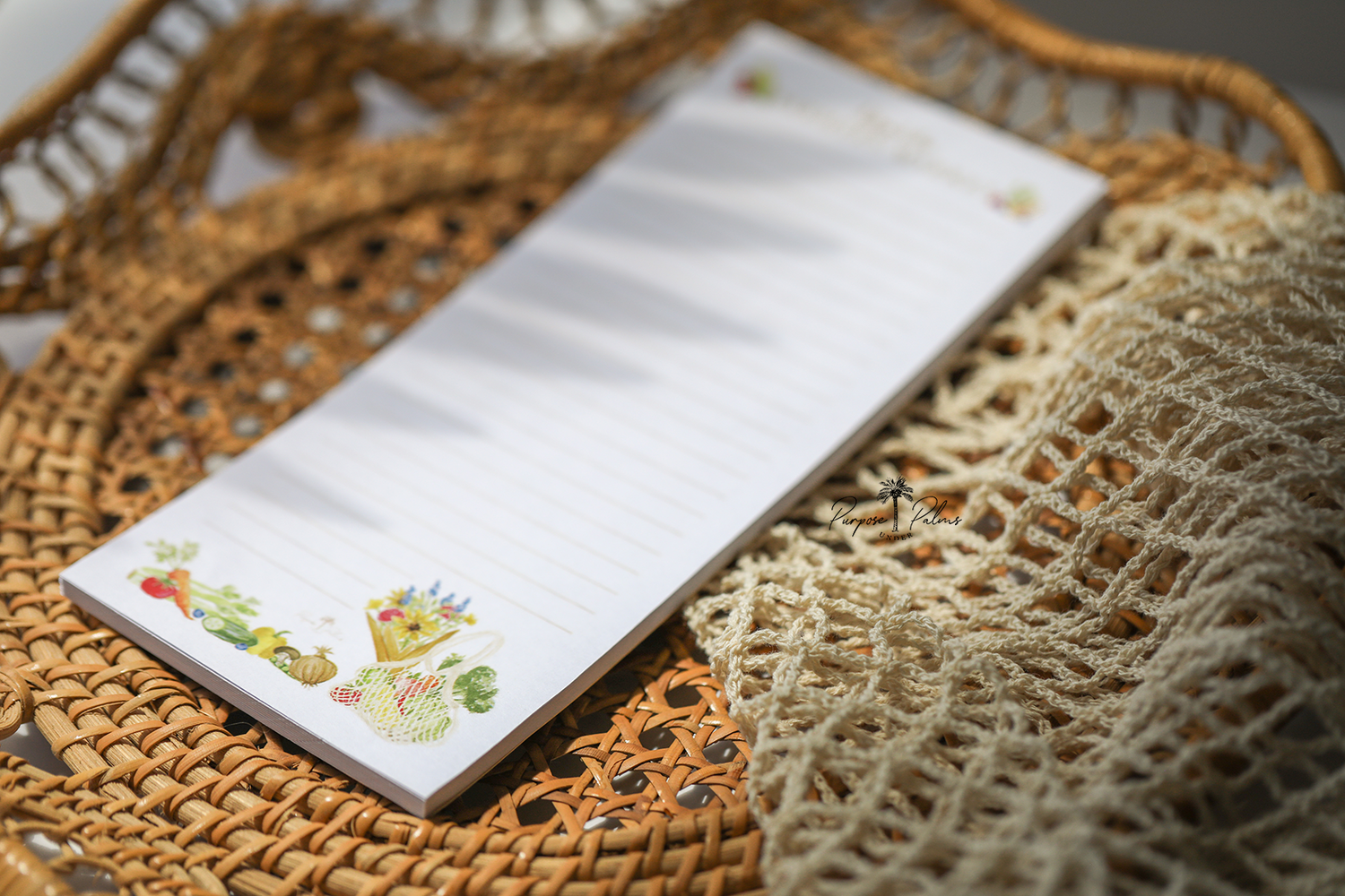 white grocery list notepad. lets go to the farmers market shown at top with fruits and vegetables on each side. lines down to the bottom. watercolor fruits and vegetables at the bottom with a mesh farmers market bag and a bouquet of flowers.
