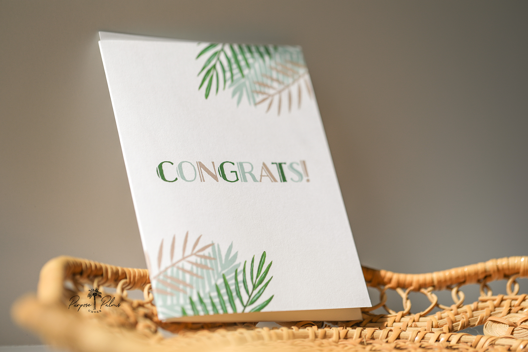 white greeting card with sage teal tan and green tropical foliage and congrats in the middle. congrats greeting card. white envelope.