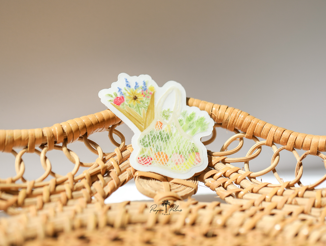small clear sticker of farmers market mesh bag with fruits and veggies inside and a bouquet of flowers sticking out of the side.
