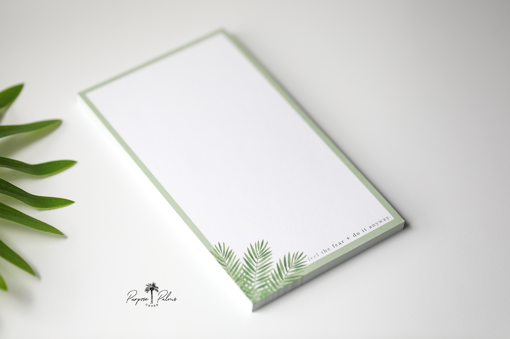 olive green and white notepad with green foliage in bottom left corner that says feel the fear and do it anyway.