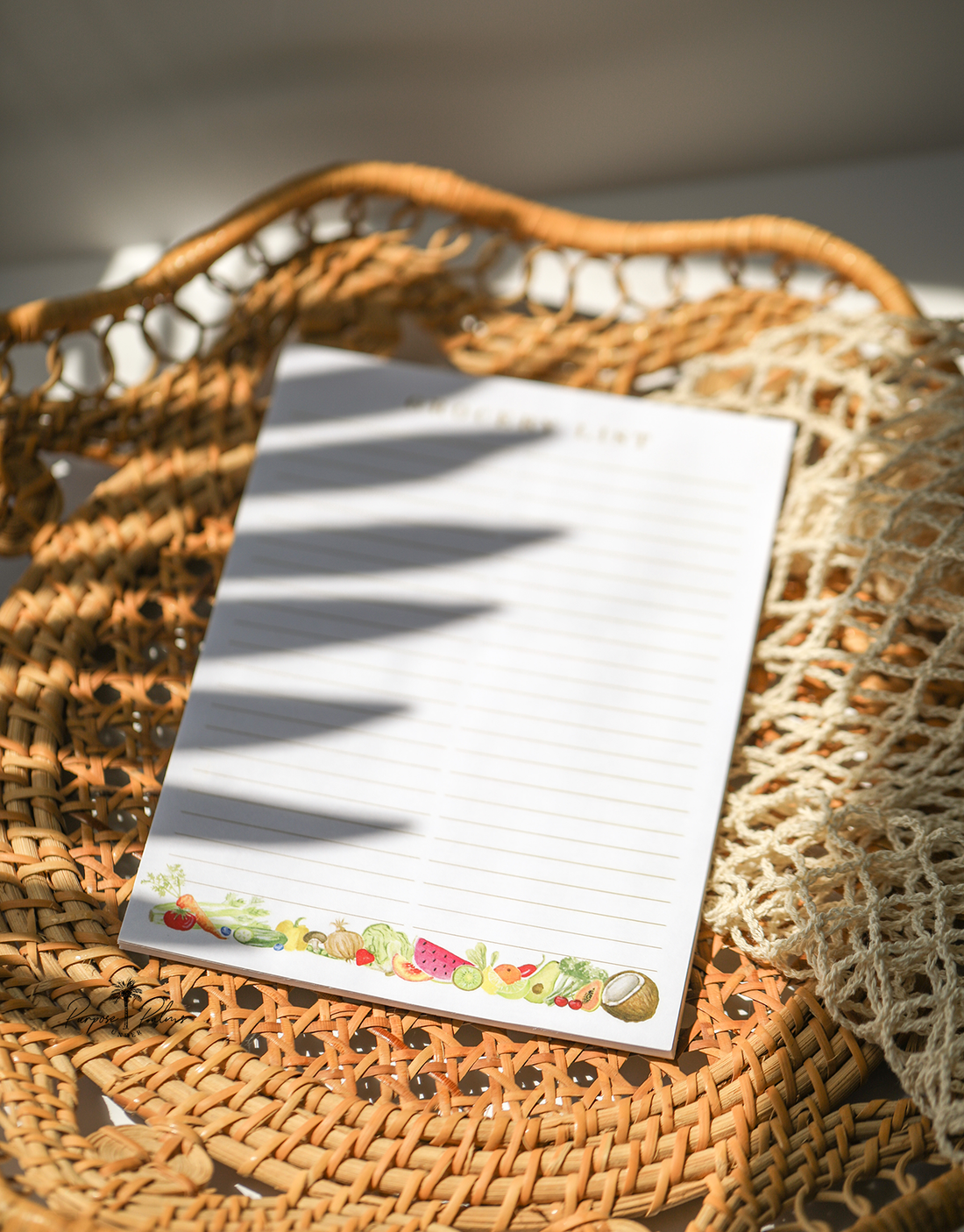 white grocery list notepad with grocery list at the top and two lined columns. watercolor fruits and vegetables at the bottom.
